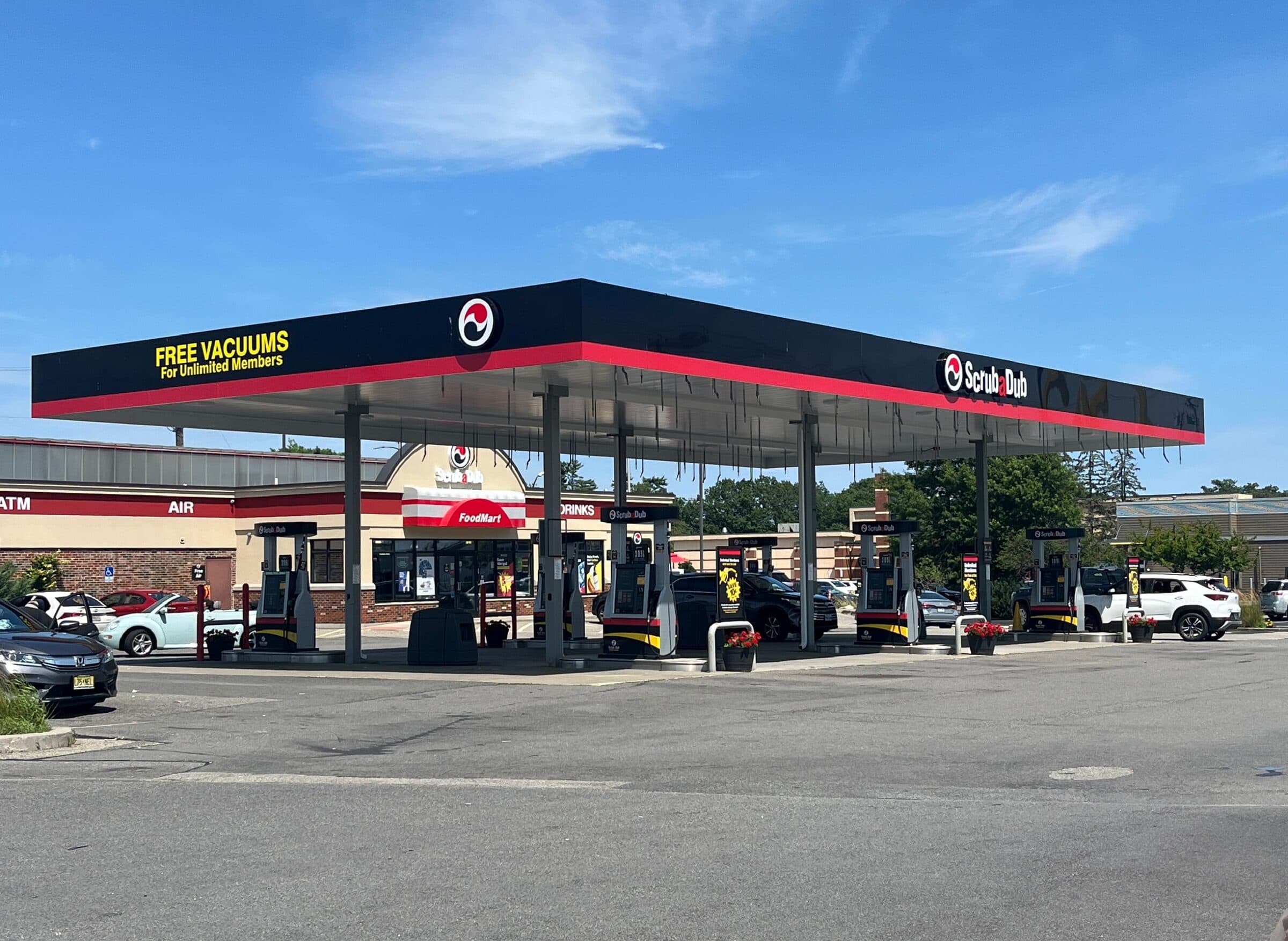 ScrubaDub gas station canopy with fuel pumps and the FoodMart store in South Portland under a blue sky
