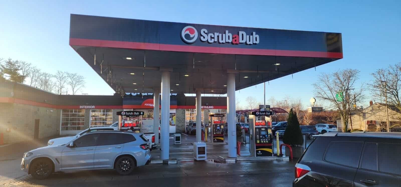 ScrubaDub gas station canopy and fuel pumps in front of the Woburn wash building in low winter sun