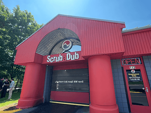 Red ScrubaDub Salem building with giant columns around the tunnel door and an OPEN sign