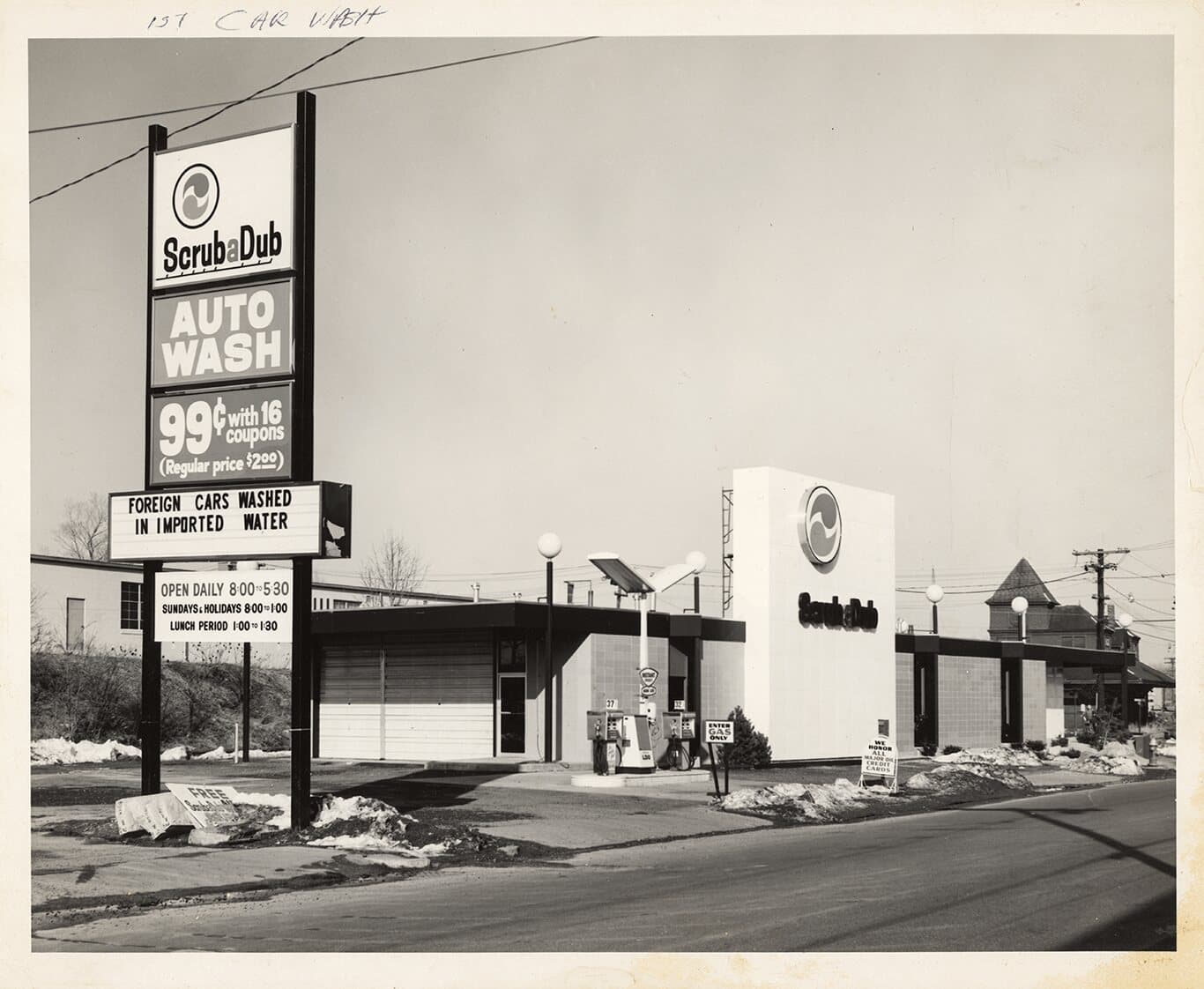 Black-and-white photo of the first ScrubaDub Auto Wash with a sign advertising 99 cents with 16 coupons