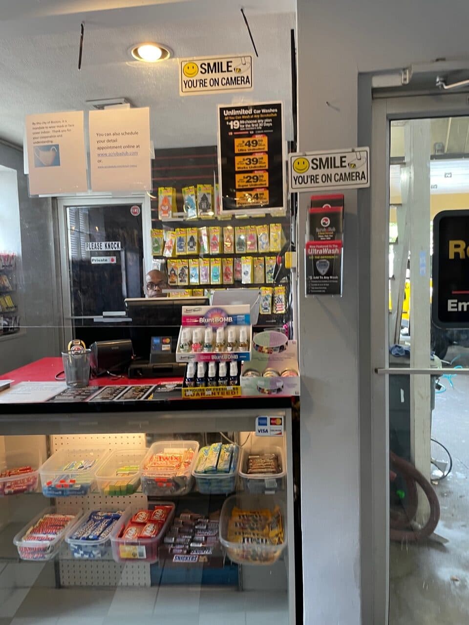 ScrubaDub cashier counter with candy, air fresheners, and an Unlimited Car Washes price sign