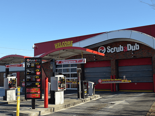 ScrubaDub Quincy pay lanes under a red WELCOME canopy with a wash menu board