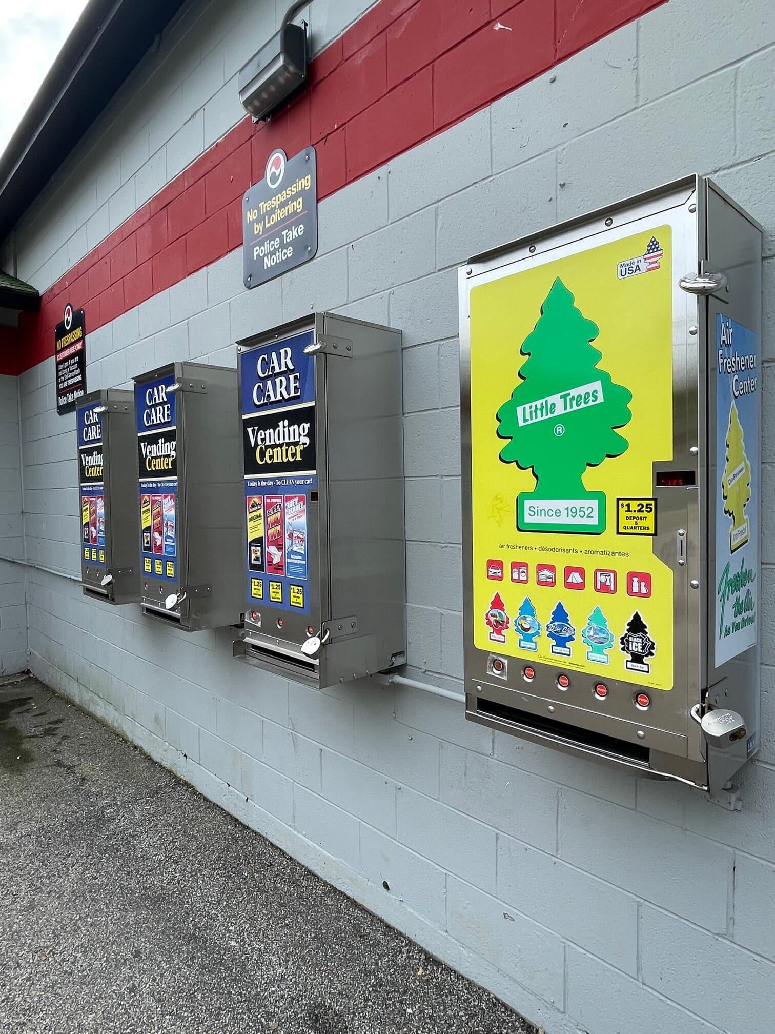 Wall of car care vending machines and a Little Trees air freshener dispenser