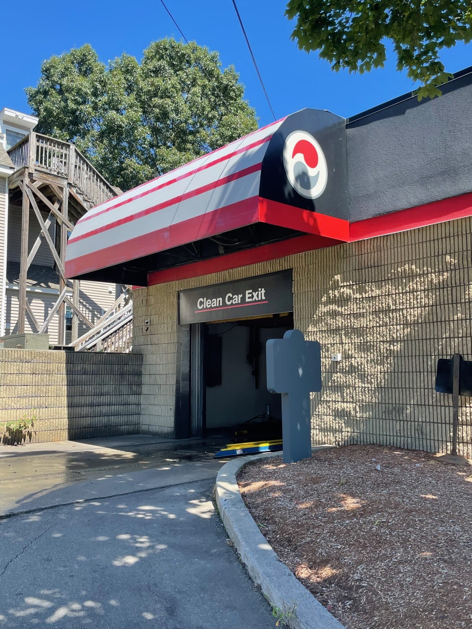 "Clean Car Exit" sign under a red, gray and white striped awning with the ScrubaDub swirl logo
