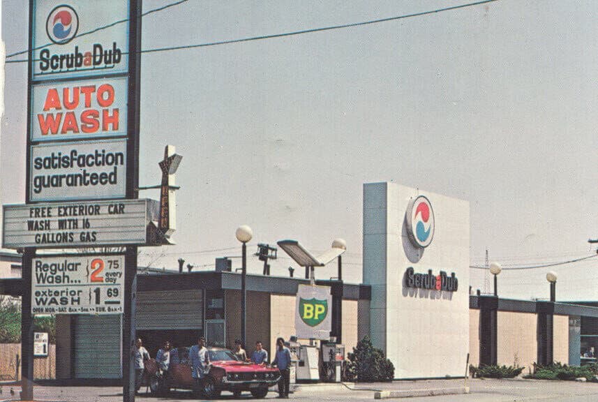 Vintage photo of the original ScrubaDub Auto Wash with a BP gas sign, price sign, and men standing by a red car