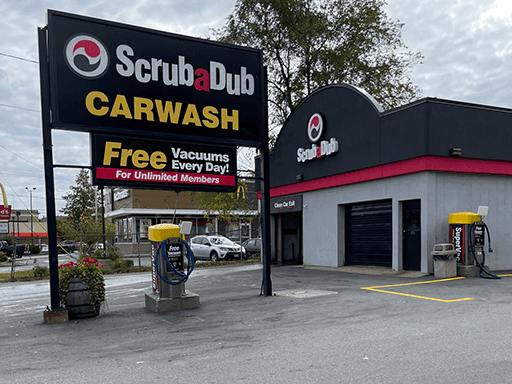 ScrubaDub Carwash sign with a Free Vacuums Every Day banner beside the Grafton Street wash building