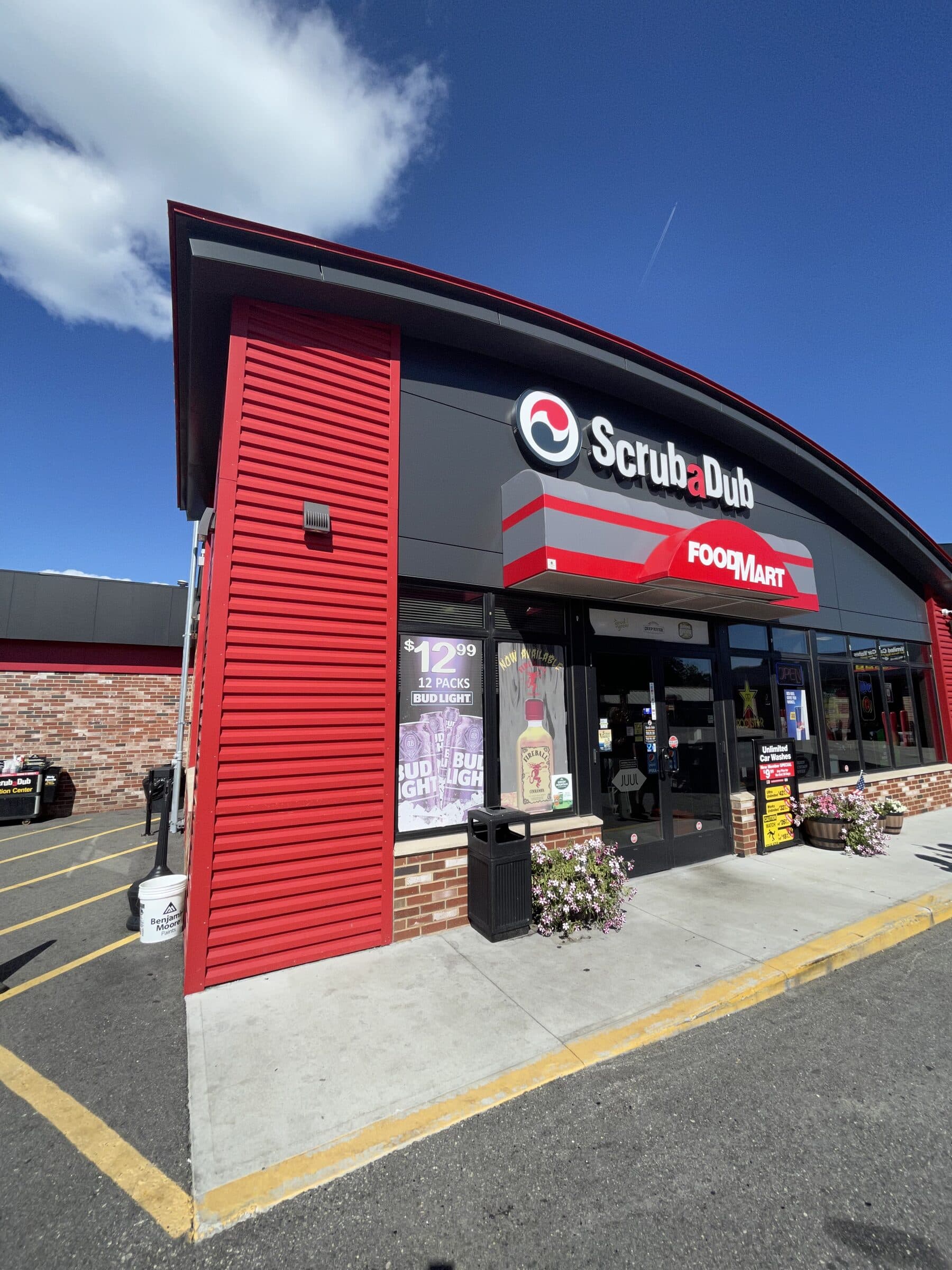 ScrubaDub Food Mart storefront with red siding and a red-and-gray awning under a blue sky