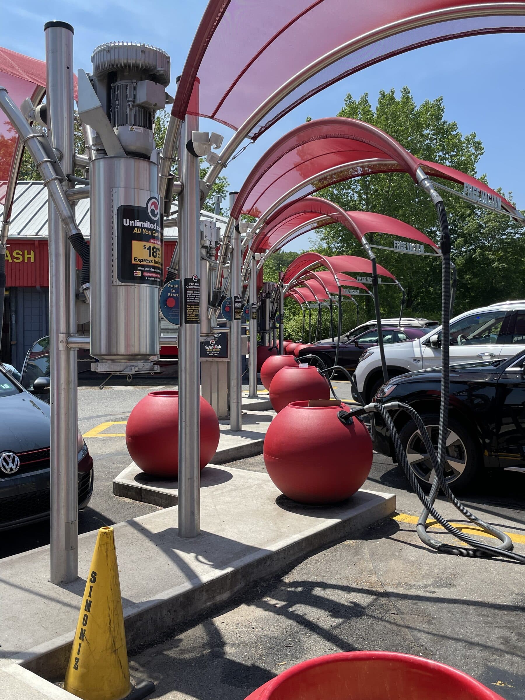 Free vacuum stations with red mesh canopies and a row of red ball trash cans