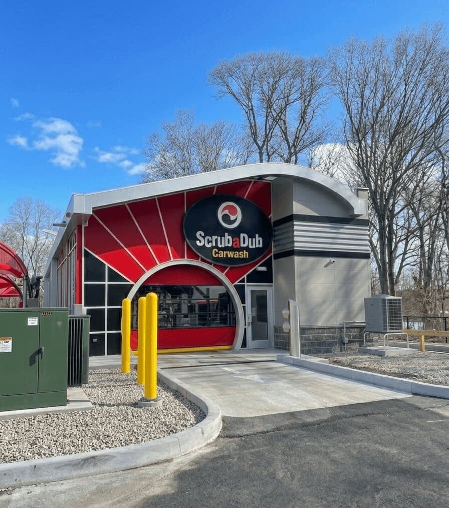 ScrubaDub Carwash building in East Greenwich with a red sunburst facade and oval logo sign