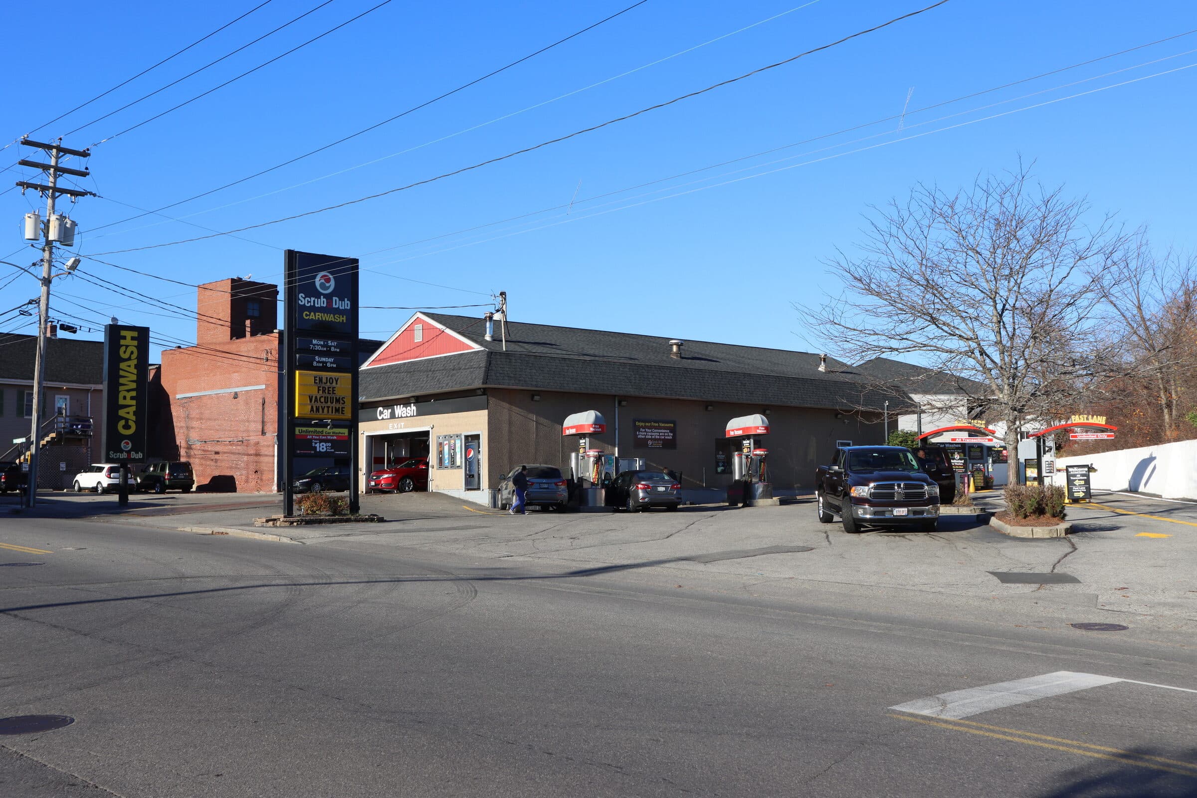 ScrubaDub Biddeford car wash seen from the street, with a tall pylon sign and red-capped vacuum stations