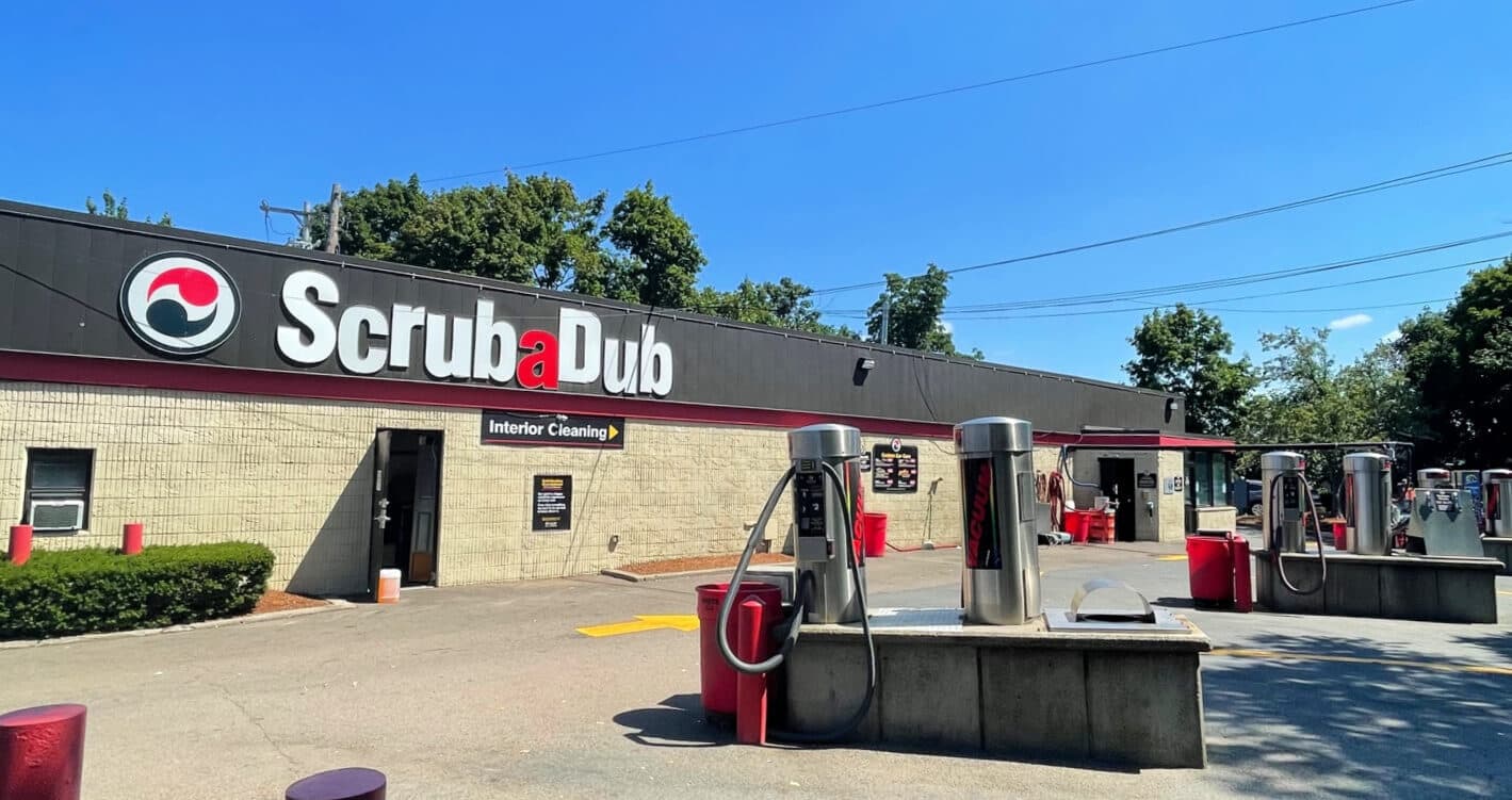 ScrubaDub Brookline building with a large ScrubaDub sign and stainless vacuum stations in the foreground