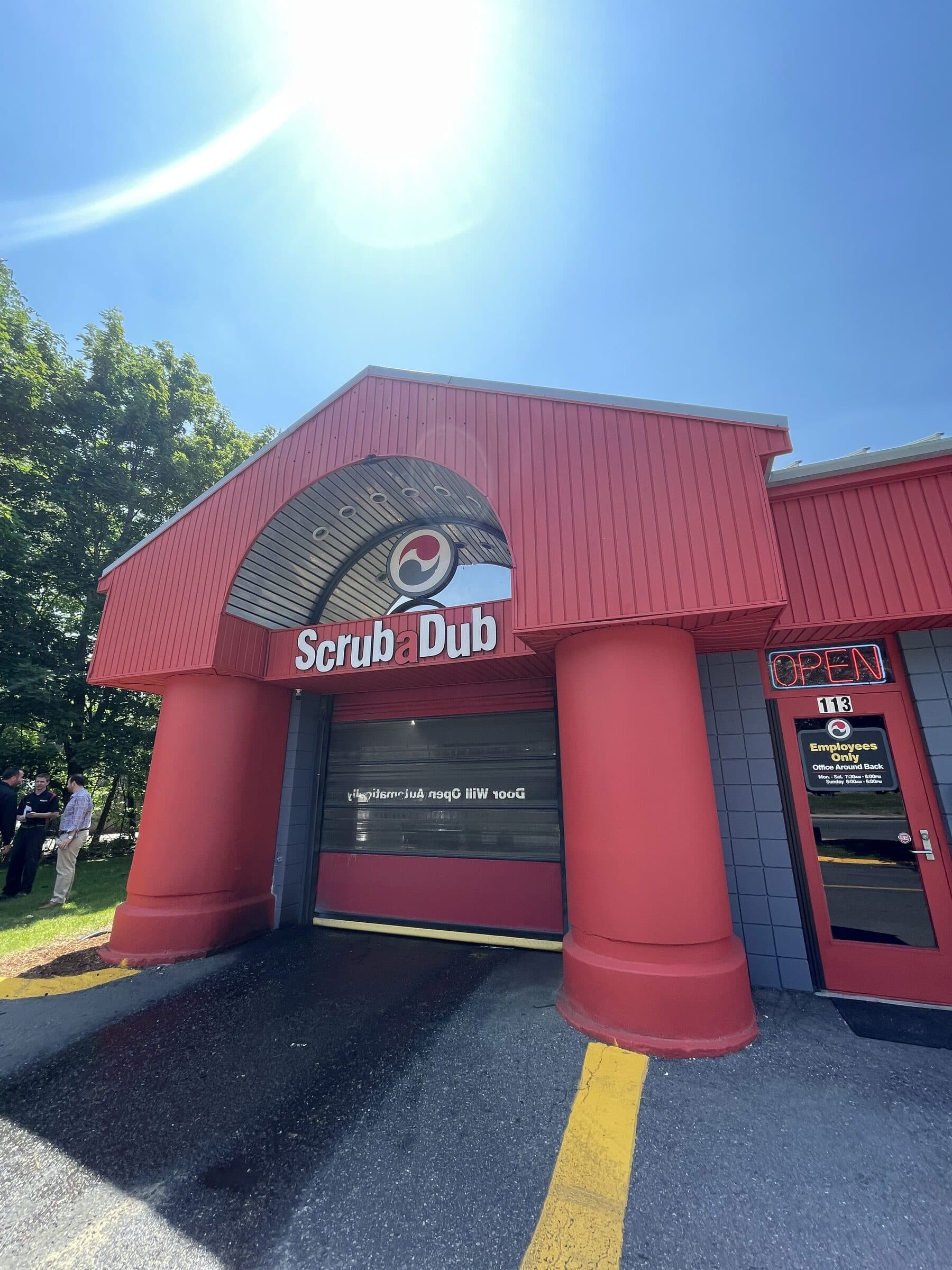 ScrubaDub Salem car wash entrance with big red columns, an arched logo window, and an "Open" neon sign