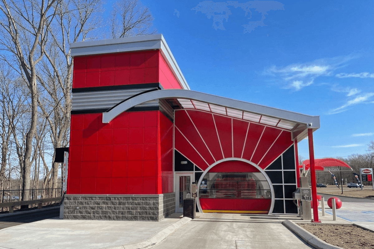 New red ScrubaDub car wash building in East Greenwich with a sunburst arch over the round tunnel door